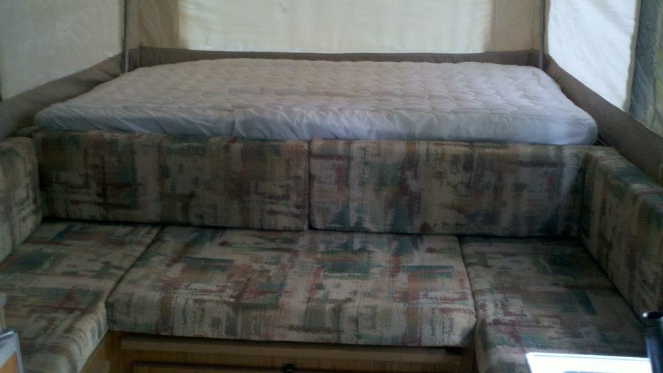Interior of the Jayco Eagle popup showing the pop-out queen bed and dinette cushions