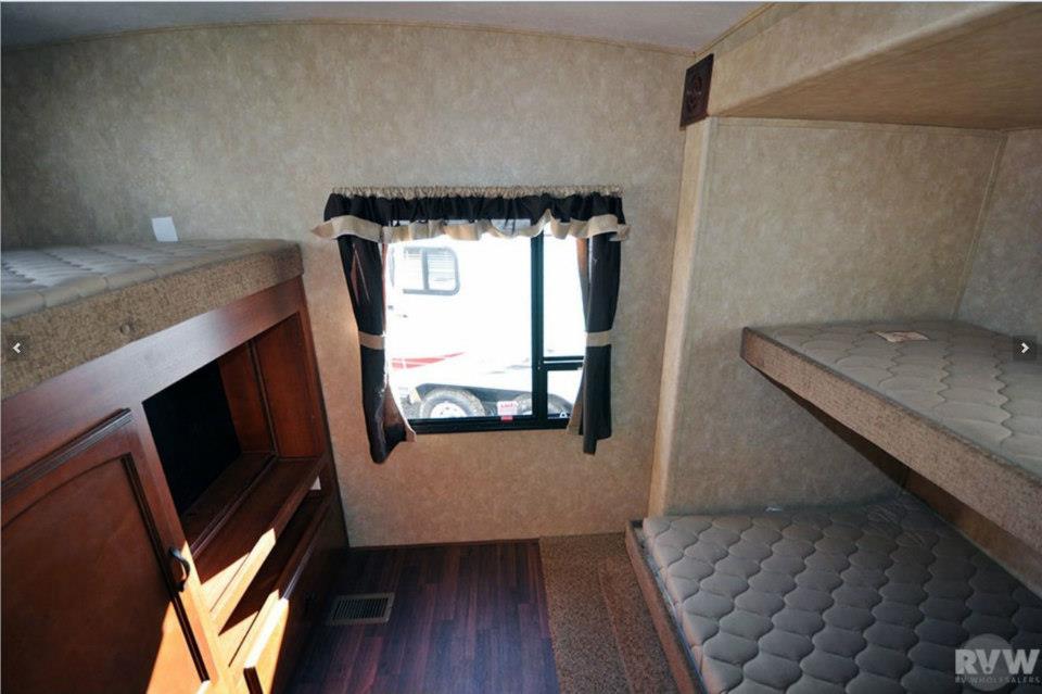 Heritage Glen rear bunk room showing the TV cabinet, swivel TV mount, and three bunk beds