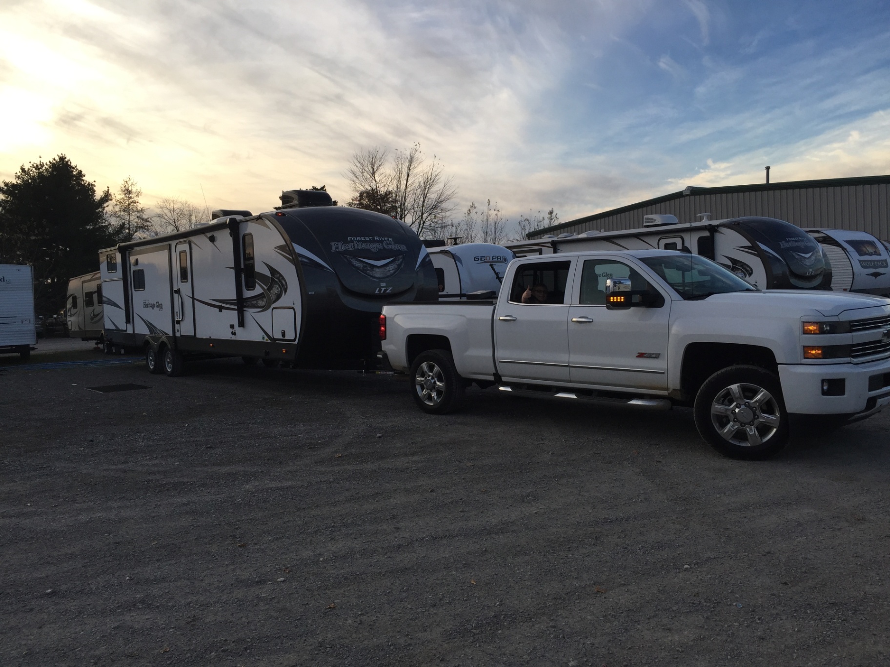Delivery day at RV Wholesalers in Ohio with the 2018 Heritage Glen LTZ 312QBUD hitched to a white Chevy Silverado at sunset