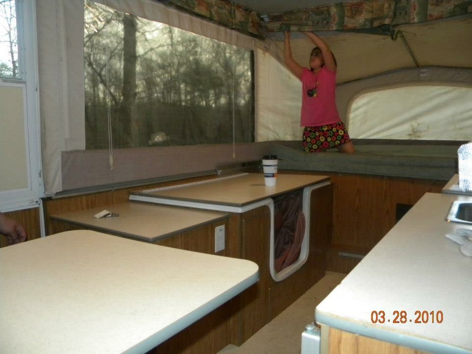 Binker Lee popup camper dinette with screen windows open to the campsite