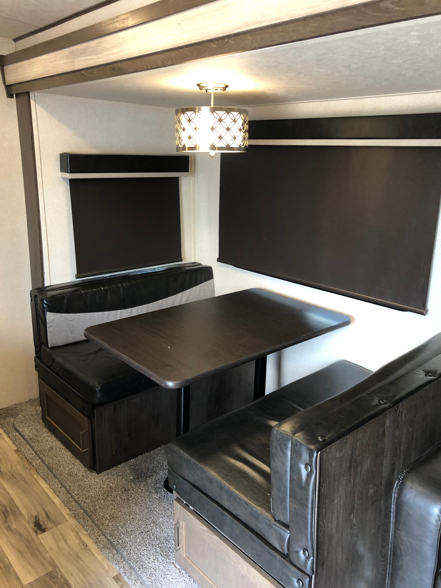 Booth dinette seating and table inside the 2018 Heritage Glen LTZ 312QBUD living area