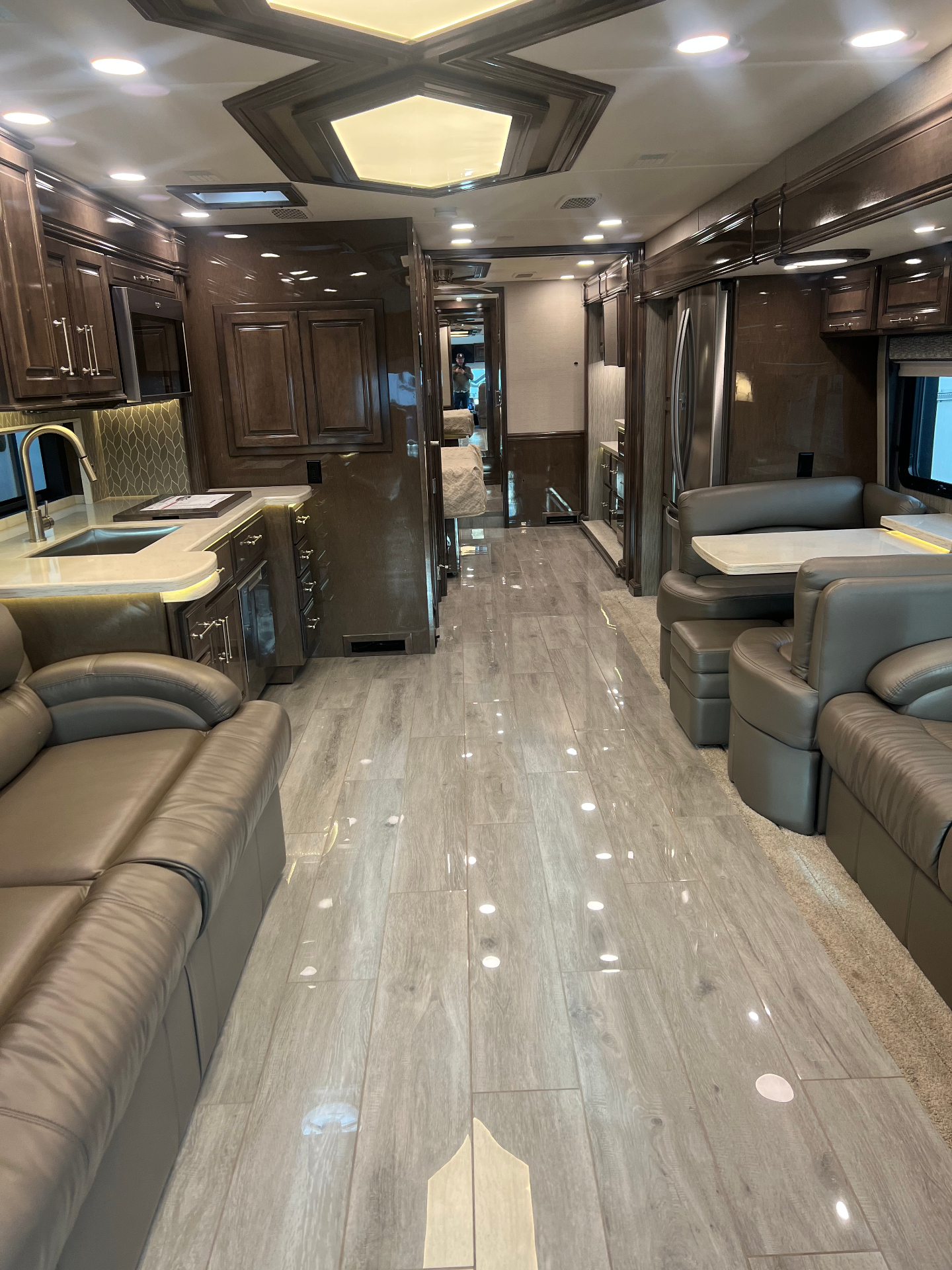Main living area inside the 2021 Entegra Aspire 44W showing the kitchen, dinette and front lounge