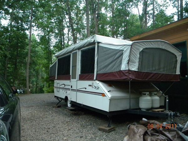 The Binker Lee 1999 Jayco Eagle popup camper fully popped up at a wooded campsite