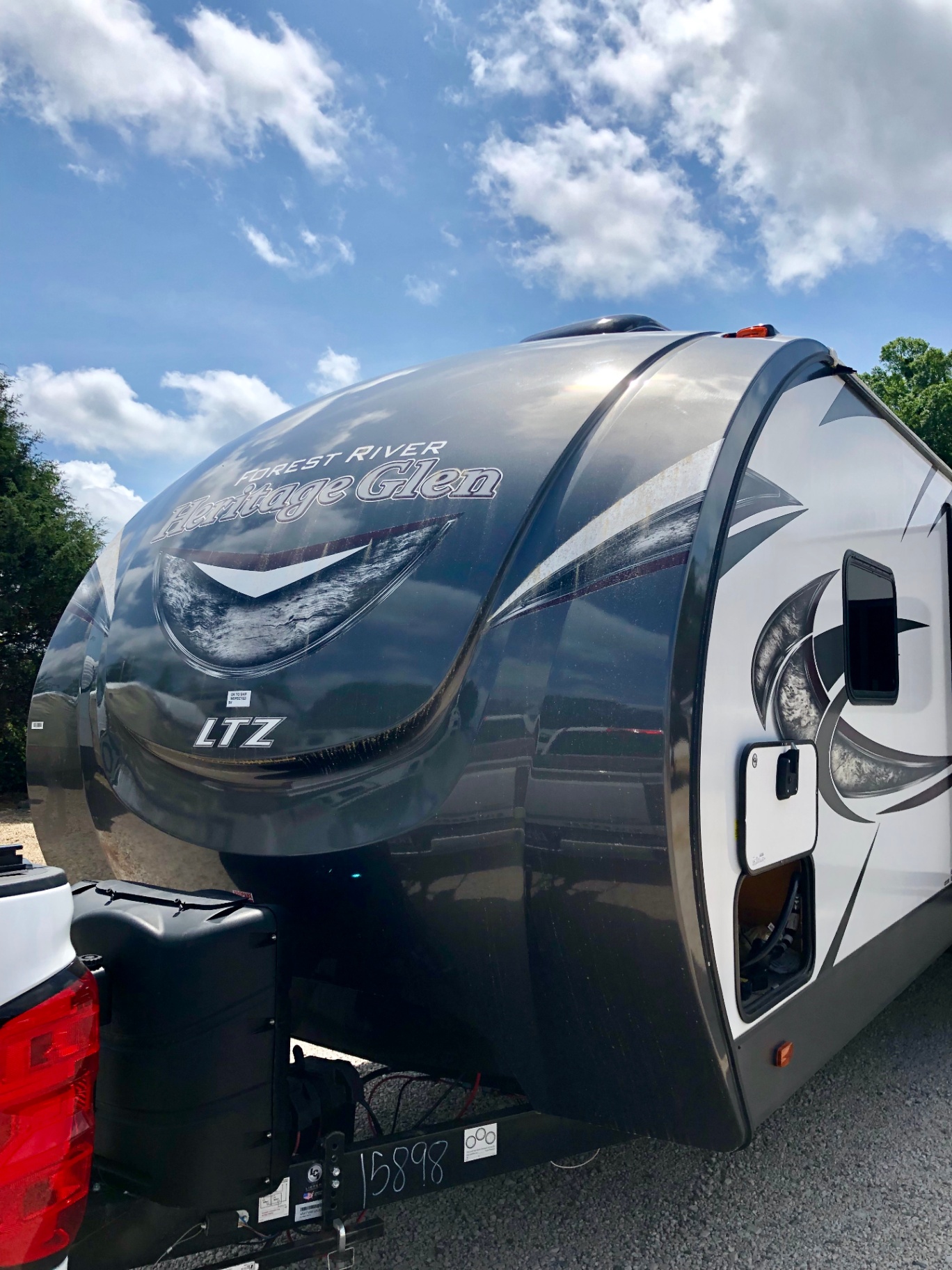 Front cap and nose profile of the 2018 Forest River Wildwood Heritage Glen LTZ 312QBUD under a blue sky