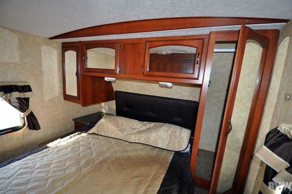 Front master bedroom of the Heritage Glen 312QBUD with queen bed, overhead cabinets, and wardrobe