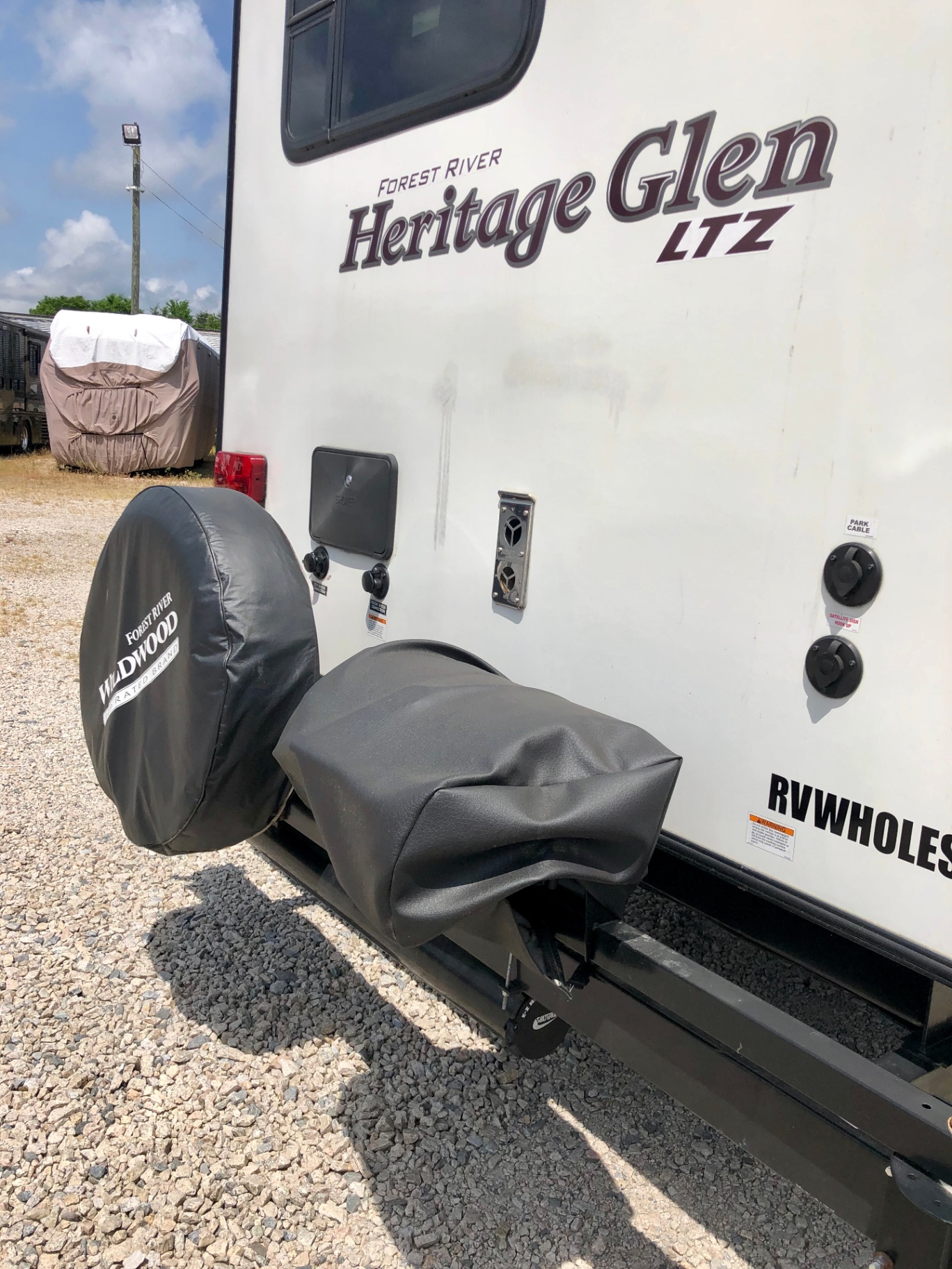 Rear wall of the 2018 Heritage Glen LTZ 312QBUD with Wildwood spare tire cover and dealer decal