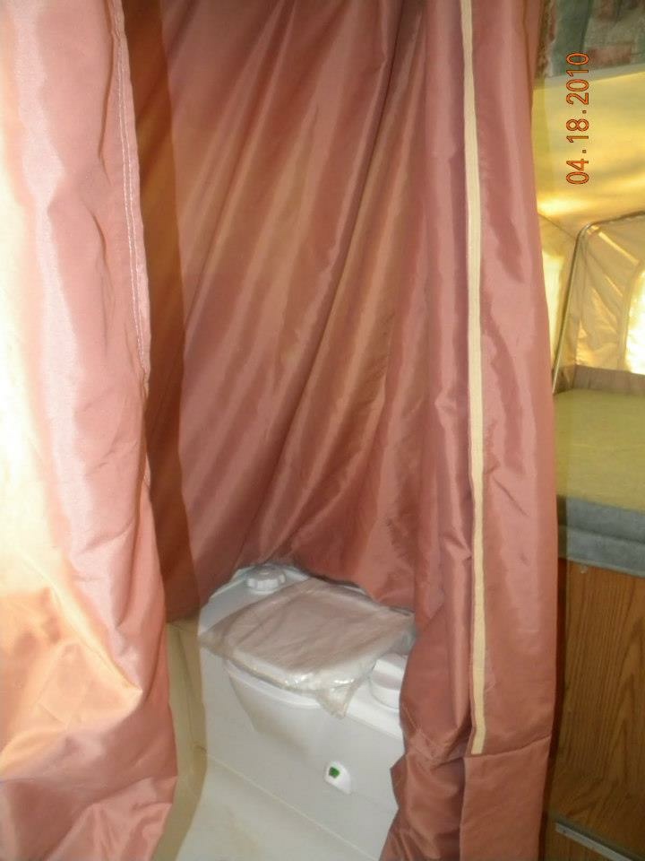 Privacy curtain pulled around the Thetford cassette toilet in the popup wet bath