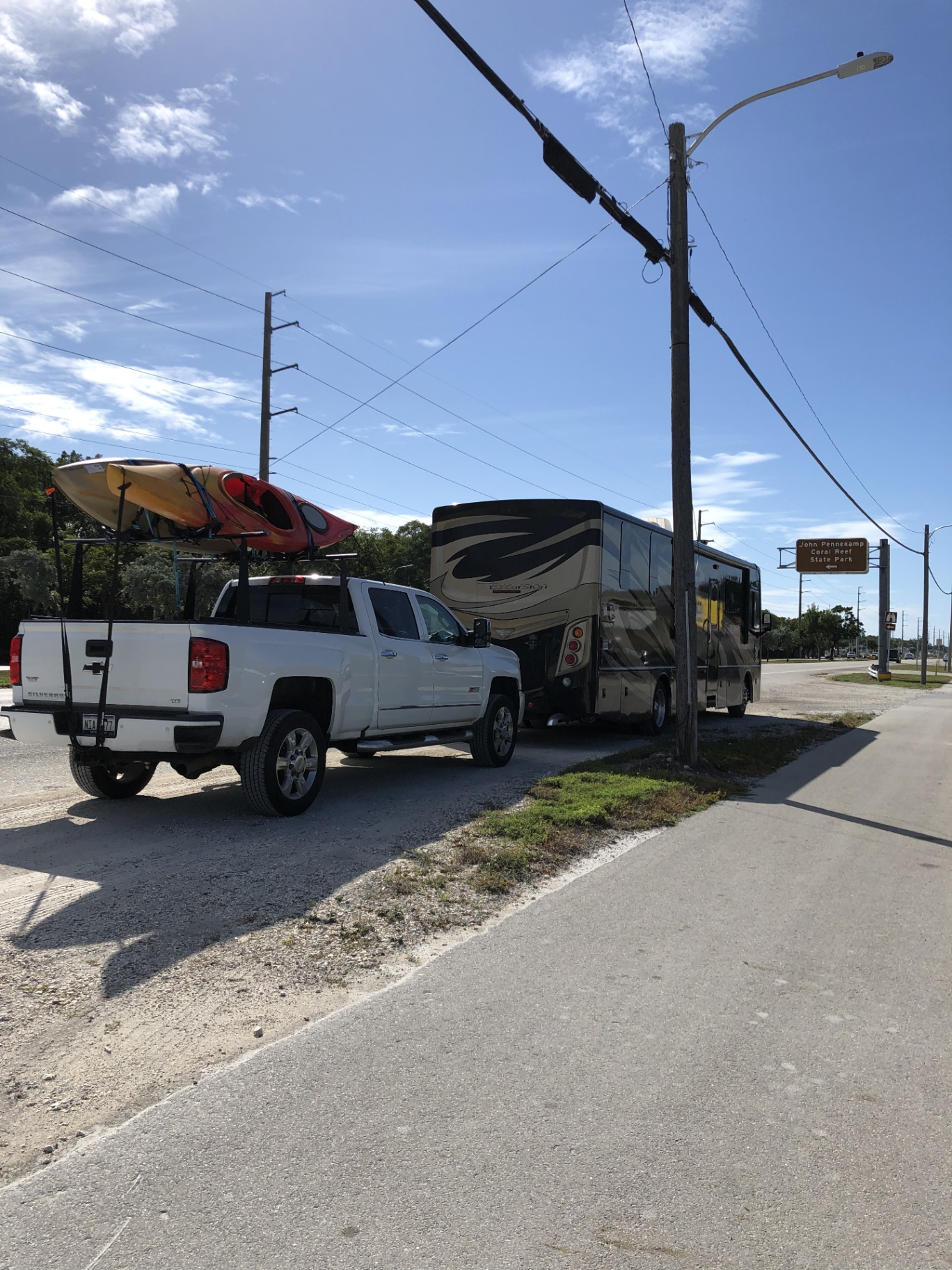 2016 Fleetwood Excursion 35E roadside in the Florida Keys with a Chevy Silverado carrying kayaks near John Pennekamp Coral Reef State Park